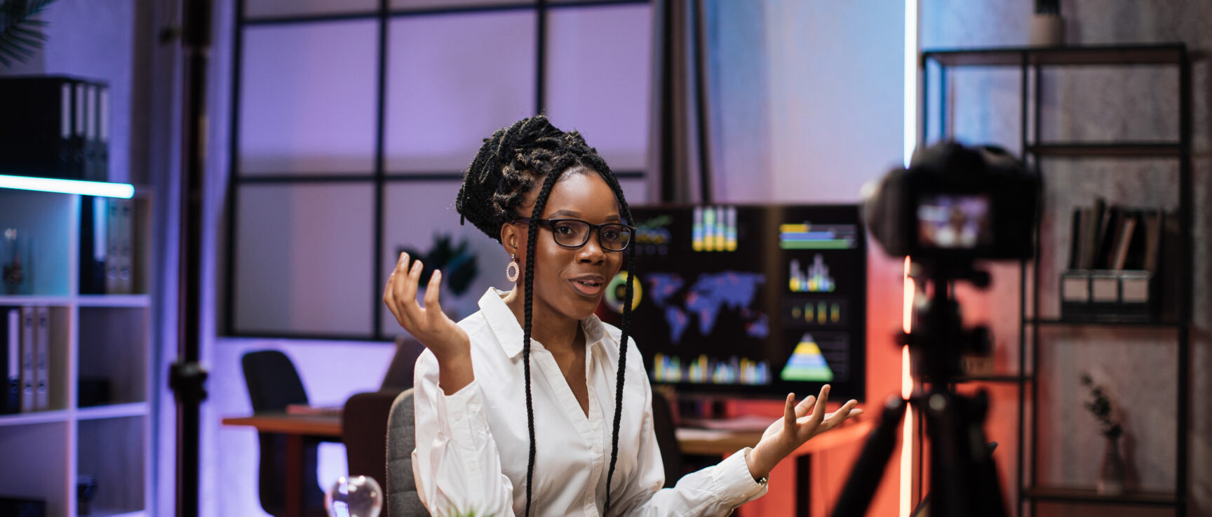 Confident african american businesswoman, broker in white shirt sitting in front of camera